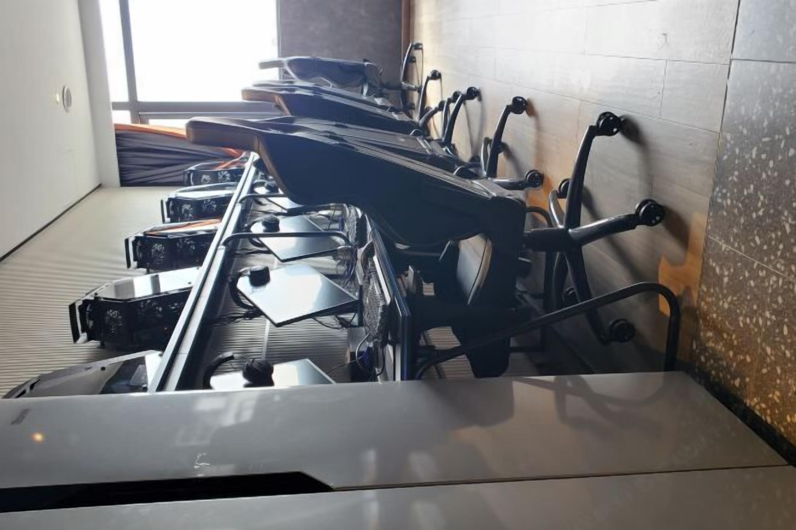 A row of stationary exercise bikes in a room with tiled walls and a window.