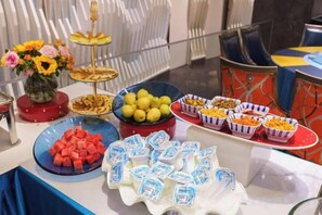 A buffet table with various food items and a decorative centerpiece. - Holiday Inn Yining Enjoy· Yi Banana Leaf (Yining Airport Branch) (Yining City)