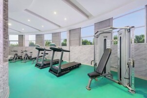 A gym with treadmills, a bench press, and a squat rack.