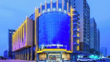 A hotel with a curved facade, multiple floors, and a prominent entrance.