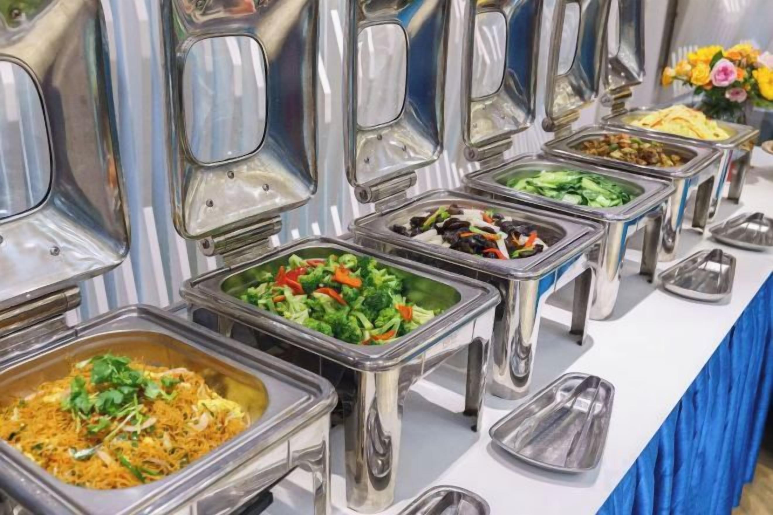 Un bufé con varias estaciones de comida, cada una con una gran variedad de platos.
