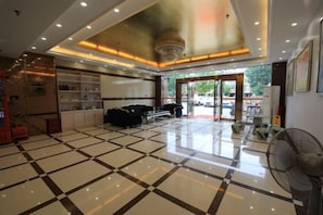 A hotel lobby with a checkered floor, a reception desk, and a large fan. - Hancheng Express Hotel (Anqing Railway Station Bus Station) (Anqing)