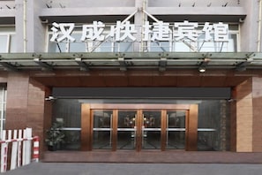 L'entrée d'un hôtel, avec une enseigne au-dessus des portes.