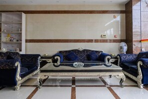 Una sala de estar con un sofá, una mesa de centro y un ventilador.