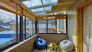 Una habitación acogedora con un ventanal grande, paredes de madera y vistas a la montaña.