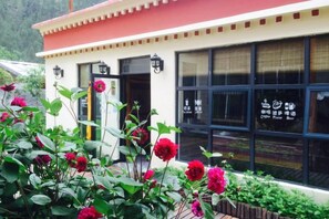 A building with a red and white facade, large windows, and a sign indicating a restaurant or cafe. - Meet Snow Mountain Boutique Residence (Bome)