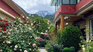 Une cour offrant une vue sur une montagne, entourée de bâtiments à l’architecture traditionnelle.