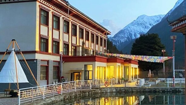 Un bâtiment traditionnel doté d’un balcon, d’une petite piscine et surplombant un paysage montagneux.