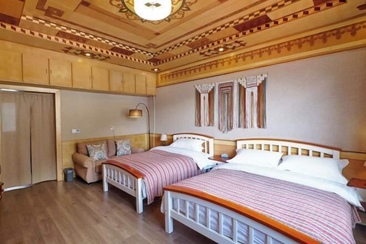 Une chambre avec deux lits, un canapé et une armoire.