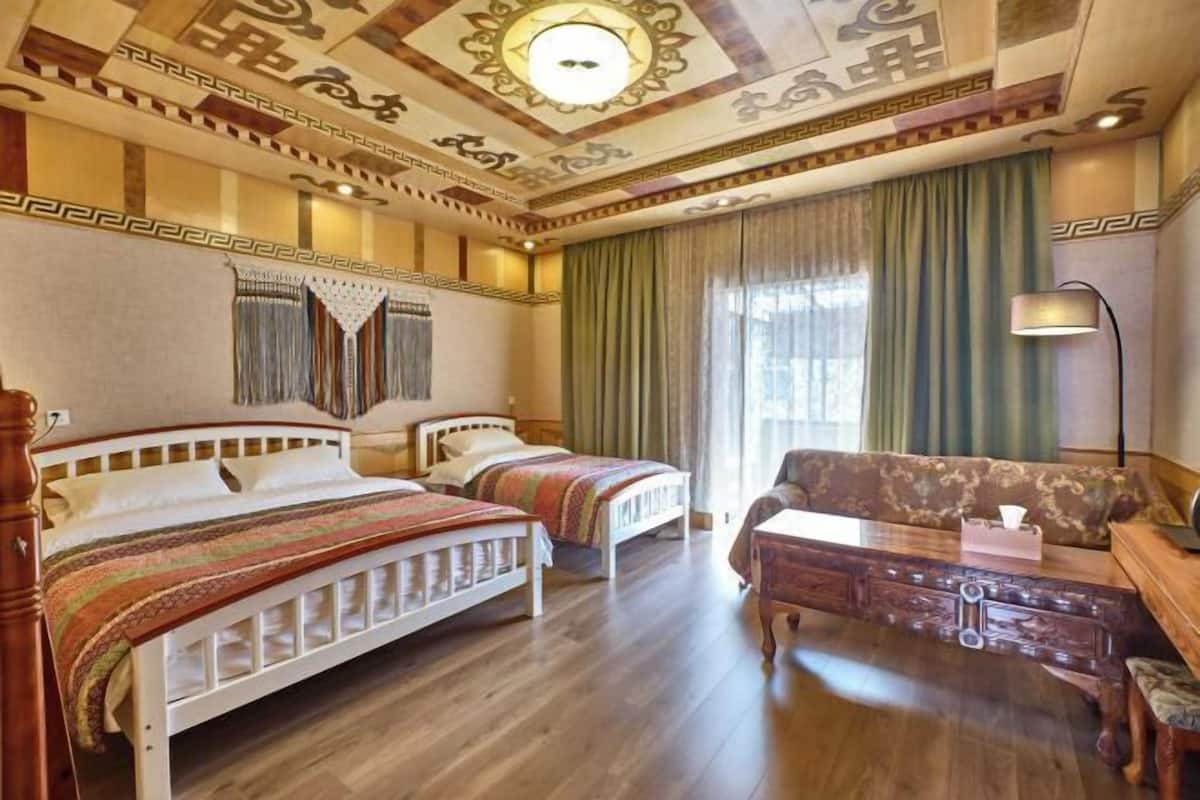 Une chambre d’hôtel avec deux lits, un canapé, un bureau et une lampe.