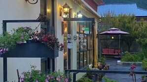 Un hôtel doté d’une entrée accueillante, d’un espace extérieur aménagé pour s’asseoir et d’un jardin.