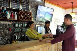 Zona de bar con mostrador, estantes con botellas y una pantalla de televisión.