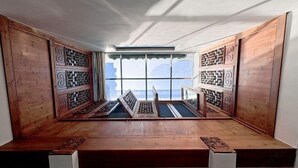 A room with a wooden bench, a window with a view, and a ceiling with a skylight. - Longxingtang (Huangshan City)