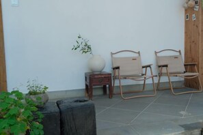 A seating area with two wooden chairs and a large vase on a small table. - Longxingtang (Huangshan City)