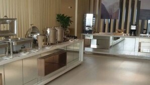 A modern kitchen with stainless steel appliances, a glass backsplash, and a plant. - Jinjiang Inn (Tianjin)