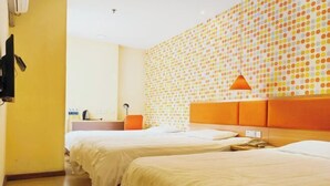 A hotel room with two beds, a wall with a polka dot pattern, and an orange headboard. - Homeinn Pebble Hotel (Huludao Passenger Terminal) (Huludao)