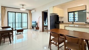A modern apartment with a dining area, kitchen, and large windows offering city views.