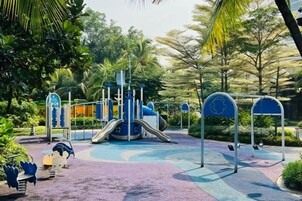 Un parque infantil con tobogán, estructuras de escalada y columpios.