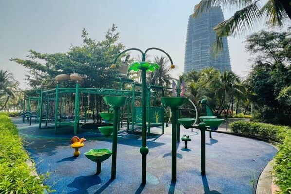 A playground with green equipment and a blue rubberized surface.