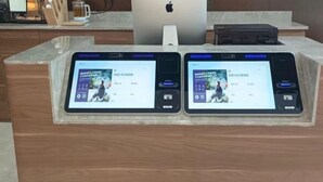 Deux tablettes posées sur un comptoir en bois, avec un ordinateur portable et une imprimante en arrière-plan.