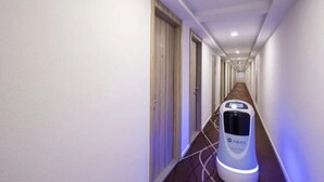 Un couloir équipé d’une balance à bagages en libre-service et d’un écran numérique.