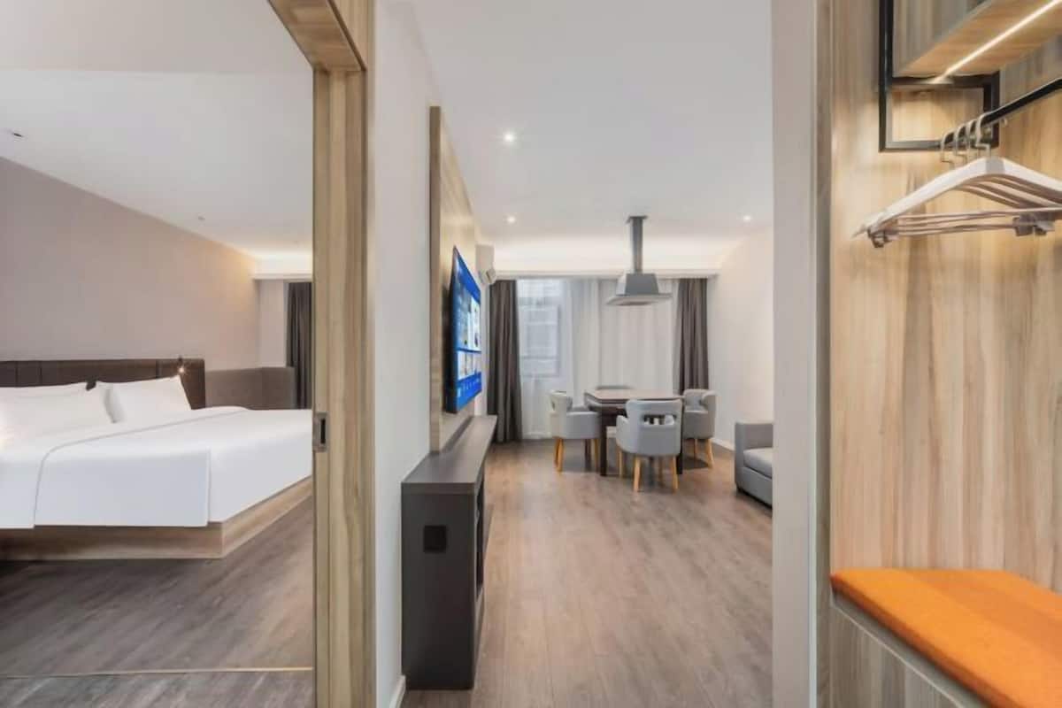 Una habitación de hotel moderna con una cama, un escritorio, una silla y un televisor.