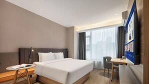 A hotel room with a bed, a desk, a chair, a small table, and a TV. - HanTing Hotel (Yueyanglou District Pipawang Overpass) (Yueyang)