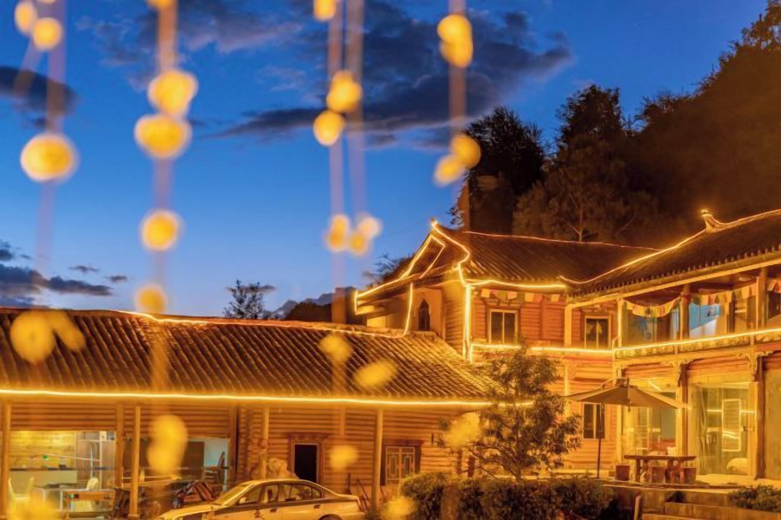 A traditional building with a covered courtyard, wooden exterior, and a car parked in front.