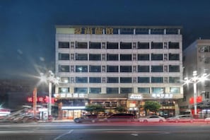 A multi-story hotel with a flat facade, multiple windows, and illuminated signage. - Aishang Hotel (Da Lang RT Mart) (Dongguan)