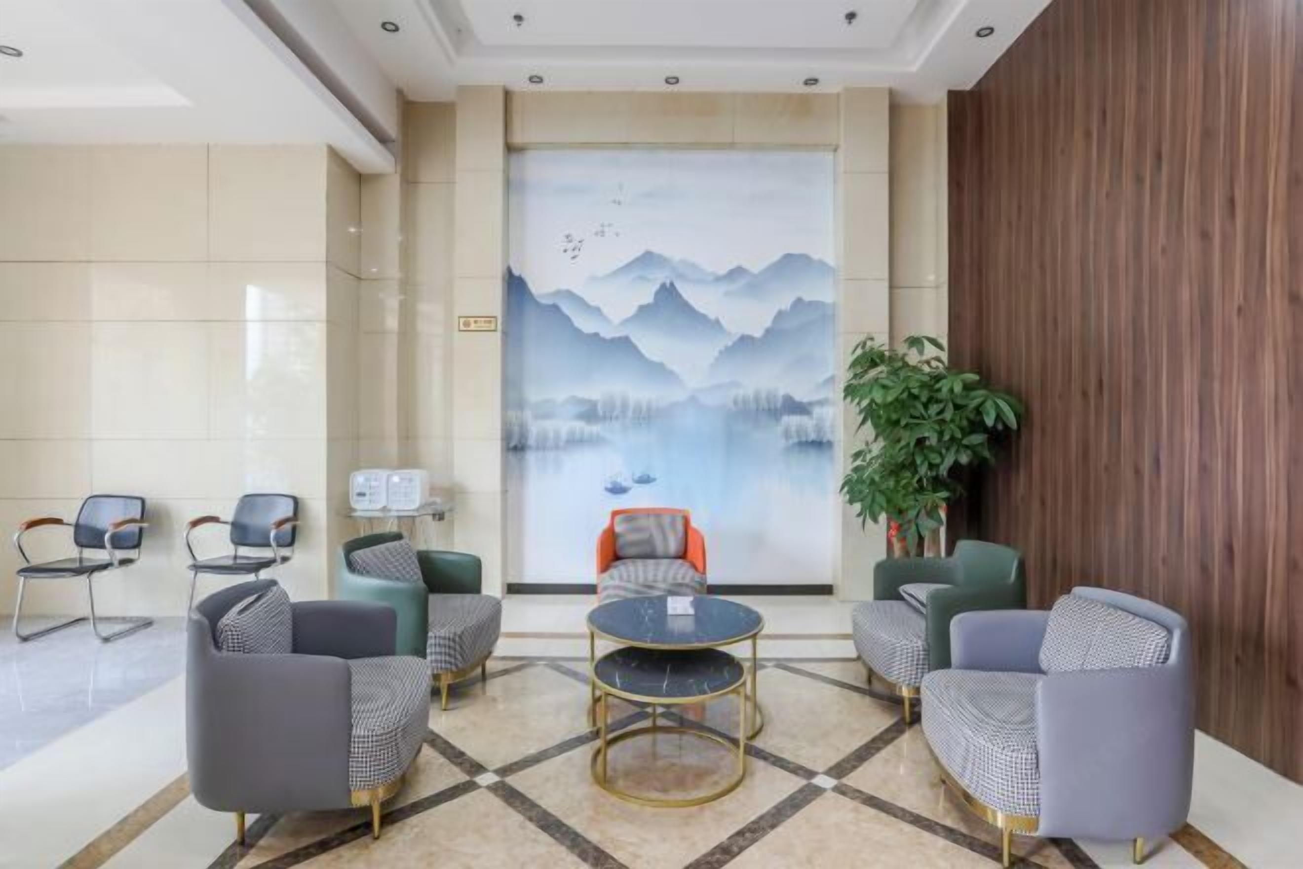 A lobby with modern furniture, a large mural, and a wooden accent wall.