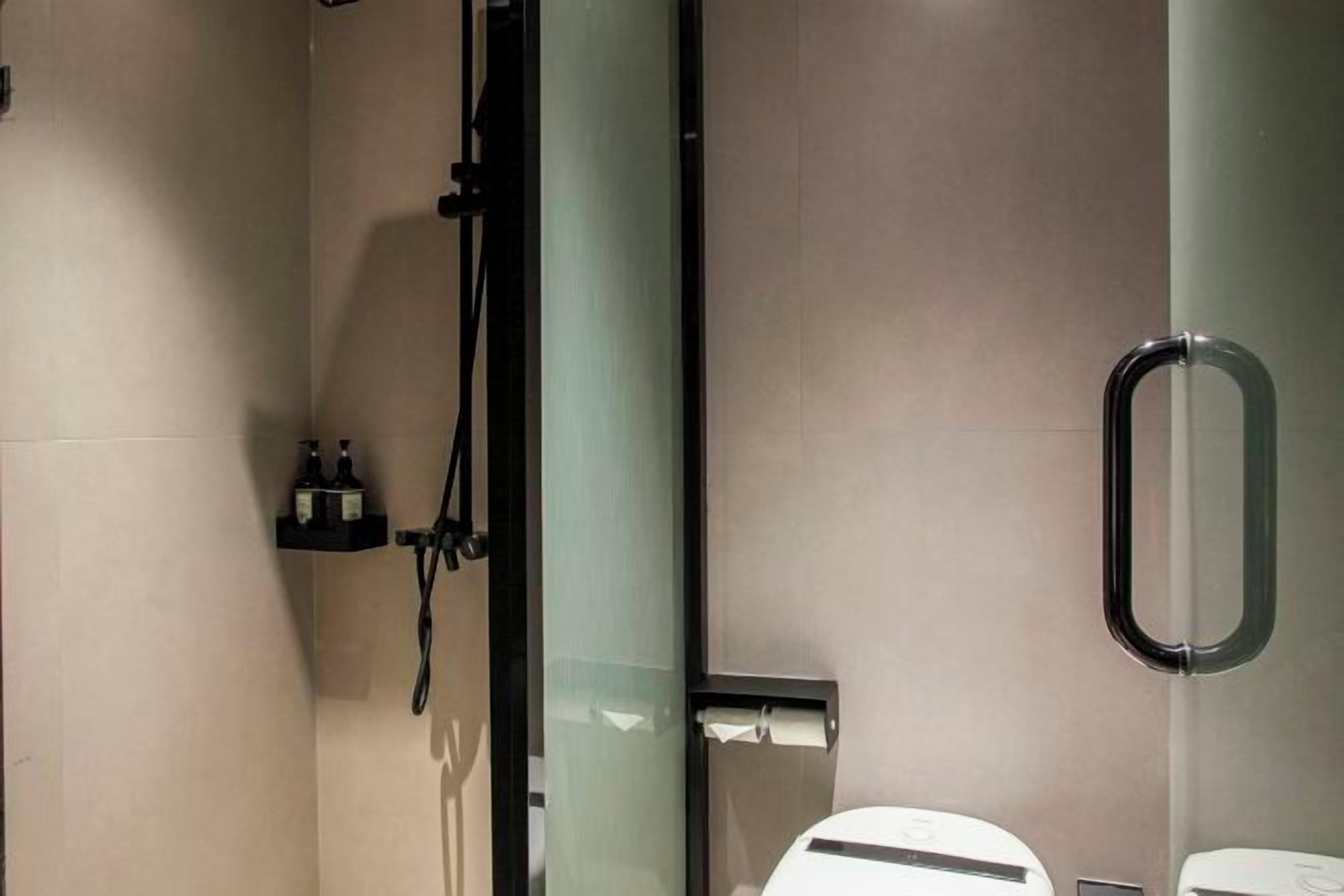 A modern bathroom with a glass partition, a shower area, and a toilet.