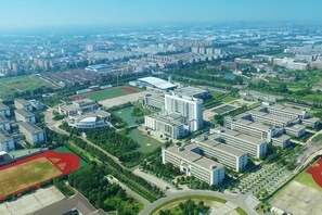 An aerial view of a campus with multiple buildings, green spaces, and sports fields.