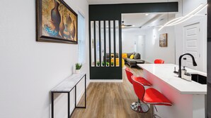 A modern kitchen with a white countertop, red bar stools, and a black backsplash. - Modern 2Bedroom house in Dallas with WiFi (Dallas)