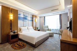 A modern hotel room with a large bed, a desk, a chair, and a TV. - Tai Zhong Hotel (Taiyuan)