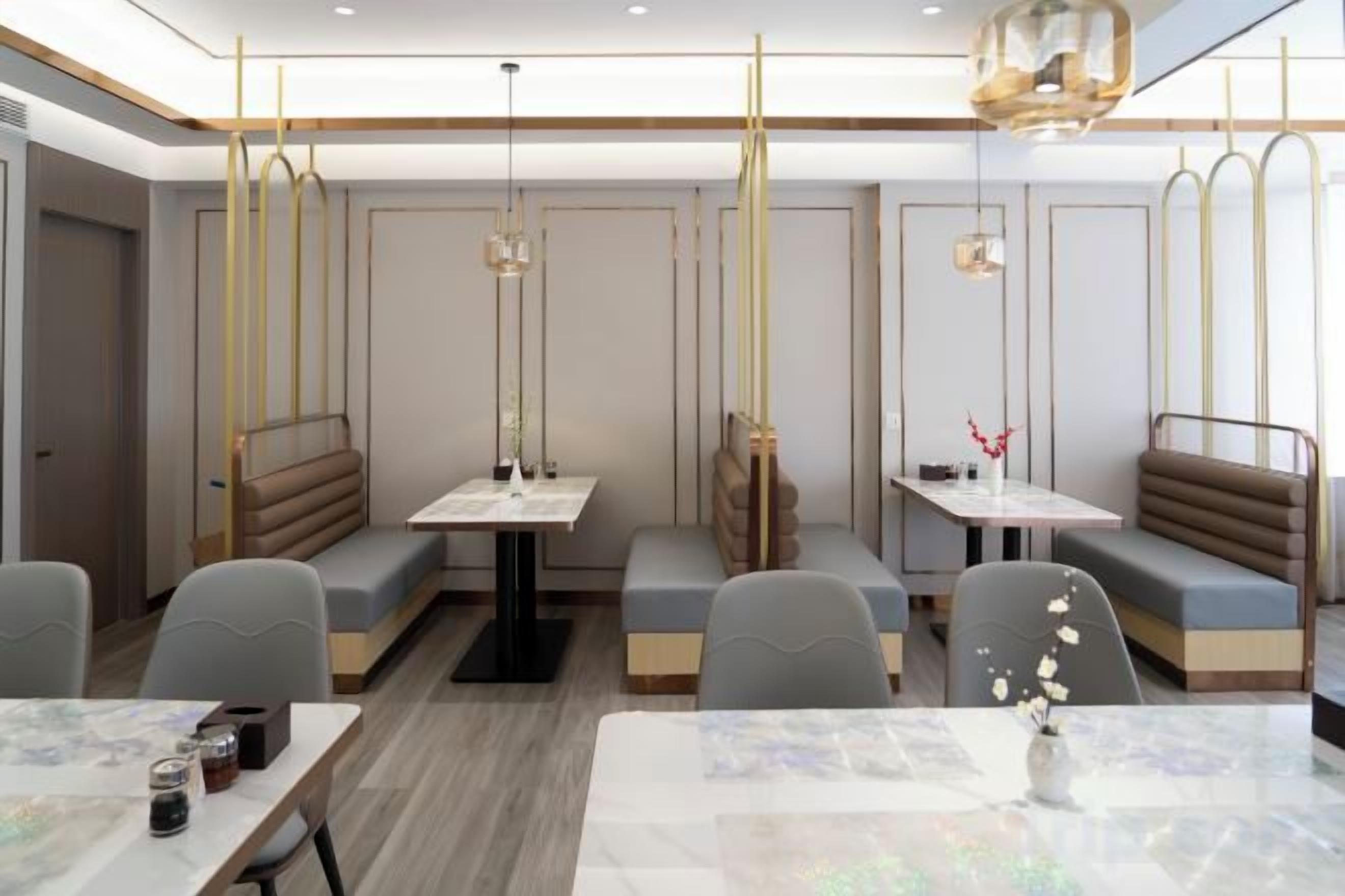 A restaurant with booths and tables, modern lighting, and a clean interior.
