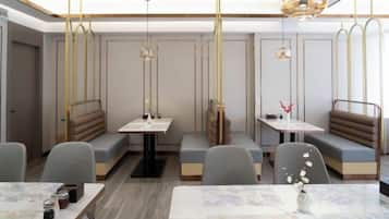 A restaurant with booths and tables, modern lighting, and a clean interior.