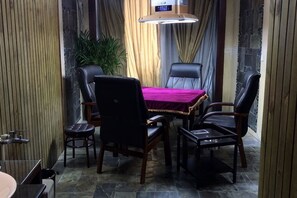A dining area with a table and four chairs, a hanging light fixture, and a potted plant. - Xitang Kaixun Boutique Hotel (Jiashan)