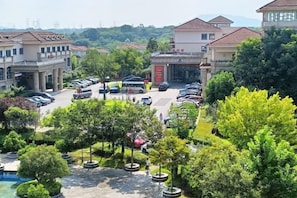 A residential area with multiple buildings, a parking lot, and a swimming pool. - Guli Hotel (Nanjing)