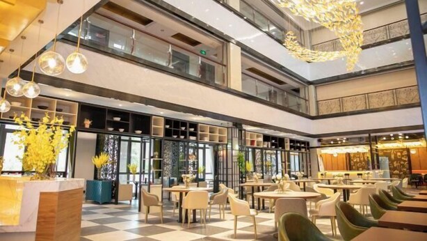 A modern indoor dining area with multiple levels, checkered flooring, and contemporary furniture. - Guli Hotel (Nanjing)