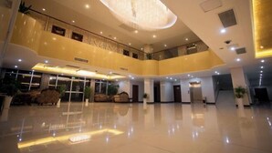 A spacious lobby with a high ceiling, a large chandelier, and a modern design. - Guli Hotel (Nanjing)