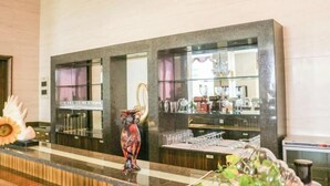 A hotel reception area with a marble counter, a decorative vase, and a glass display case with various items. - Golden Eagle Hotel (Zhoushan)