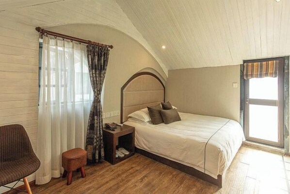 A bedroom with a bed, a chair, a nightstand, and a window with curtains. - Yuan Jin Inn (Hangzhou)