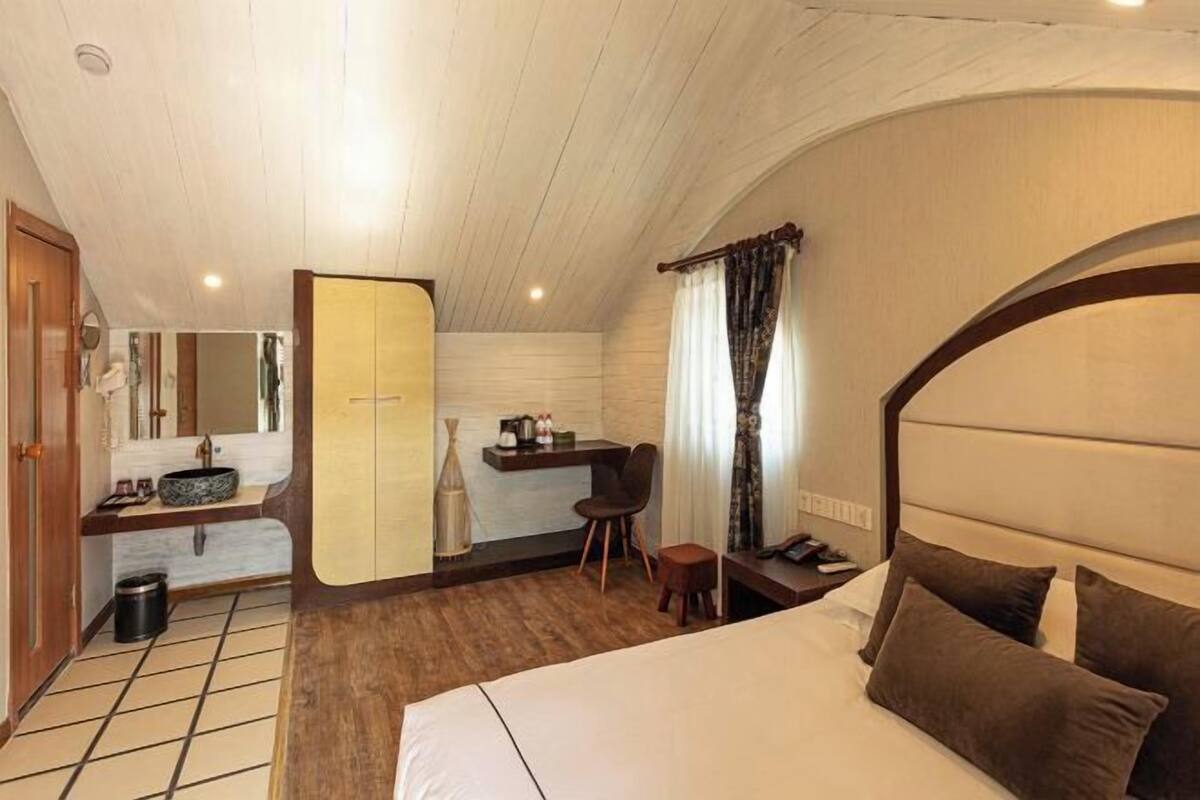 Ein Hotelzimmer mit Bett, Schreibtisch mit Stuhl, Spiegel und Badeckeiche.