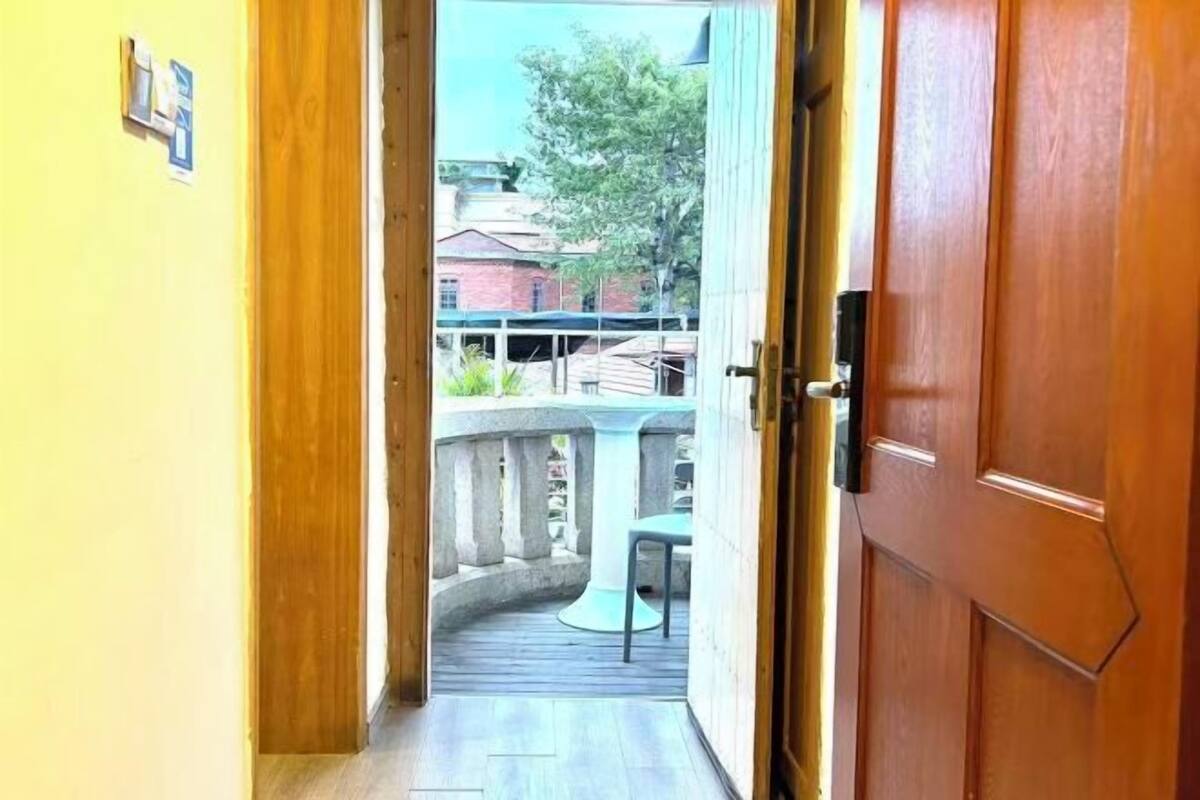 A wooden door leading to a balcony with a table and chairs.