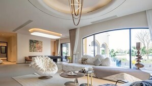 A modern living room with a sofa, a coffee table, and a unique white chair.