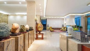 Un hall d’entrée moderne avec un comptoir d’accueil, un globe terrestre et un espace salon offrant une vue agréable.