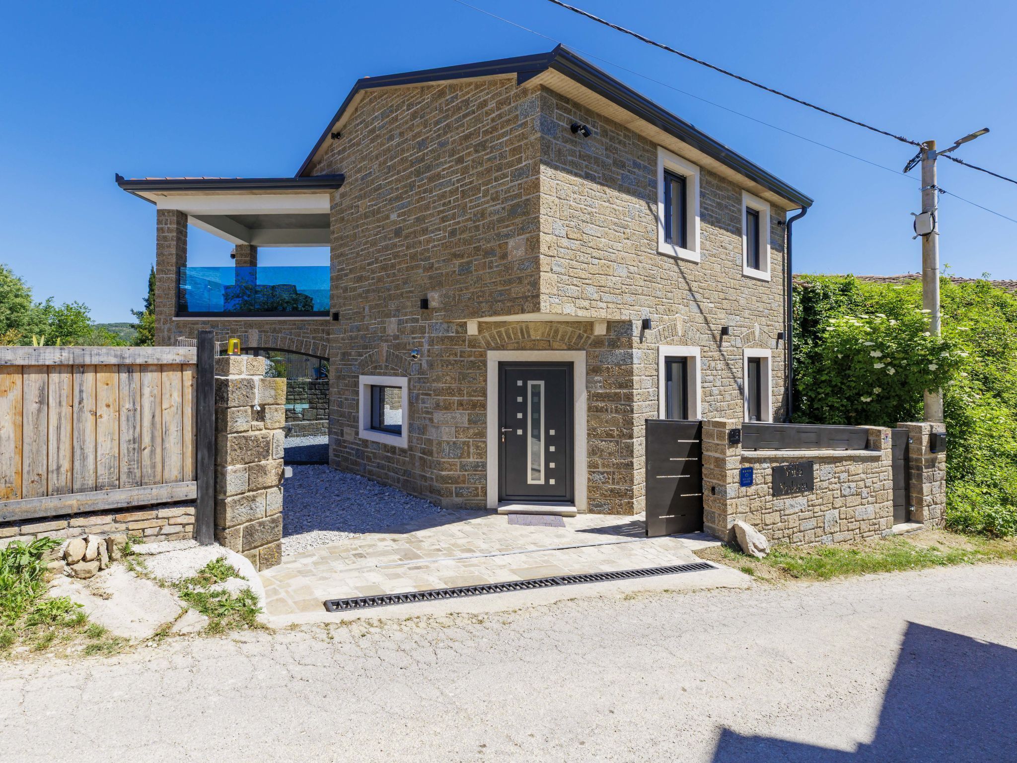 A stone building with a front door, windows, and a small balcony.