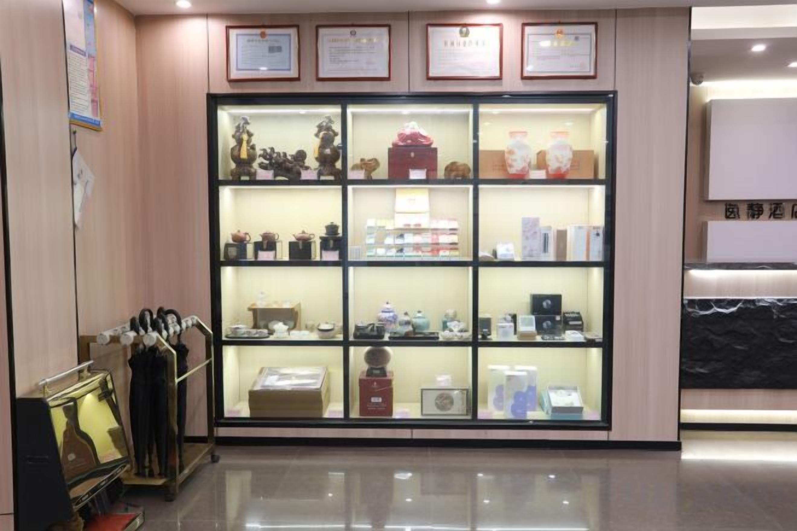 A display case with various items, including figurines and boxes, in a well-lit room with a polished floor.