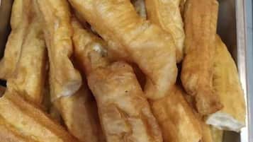 A tray of golden-brown fried dough sticks.