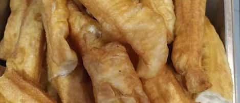 A tray of golden-brown fried dough sticks.